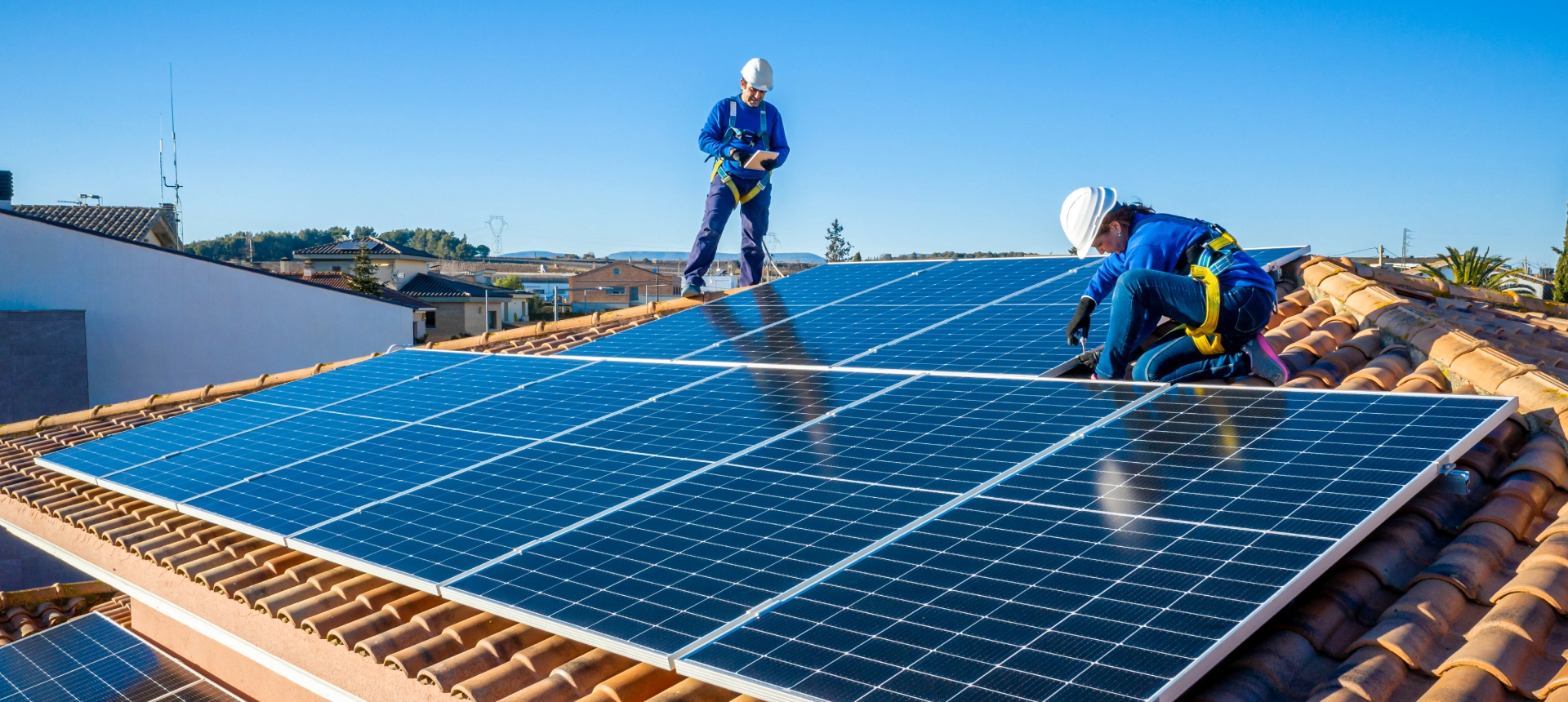 Workers installing solar panels on roof